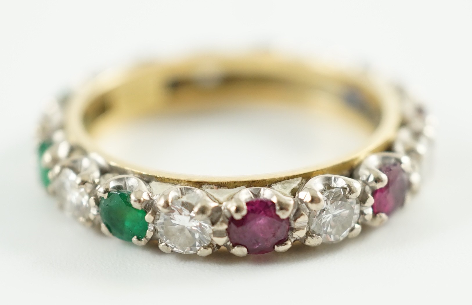 A modern 18ct gold, emerald, sapphire, ruby and diamond set full eternity ring